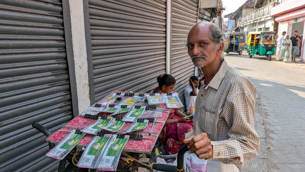 A lottery ticket seller with a display of printed tickets on a street in Mattancherry, Fort Kochi.